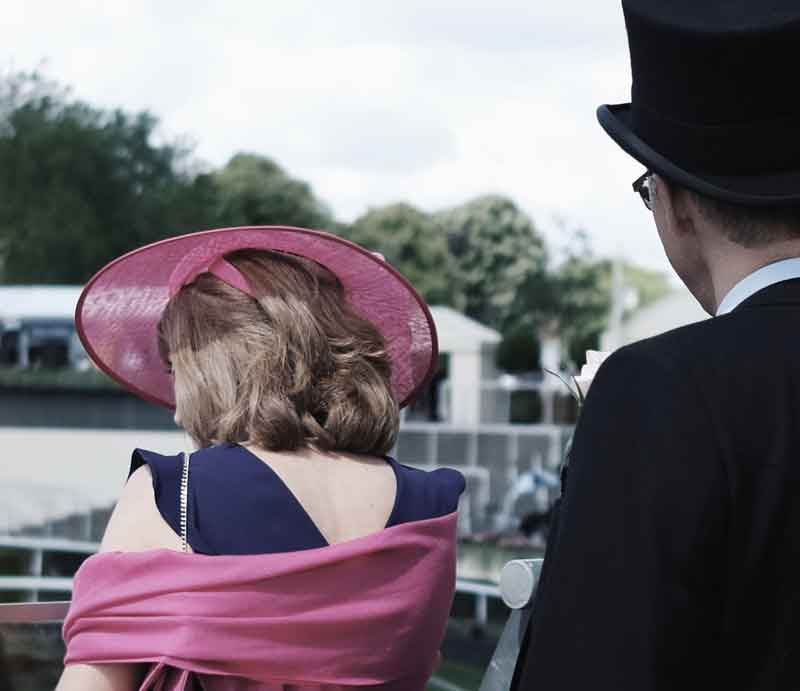 Lady in pink hat with gentleman wearing top hat.
